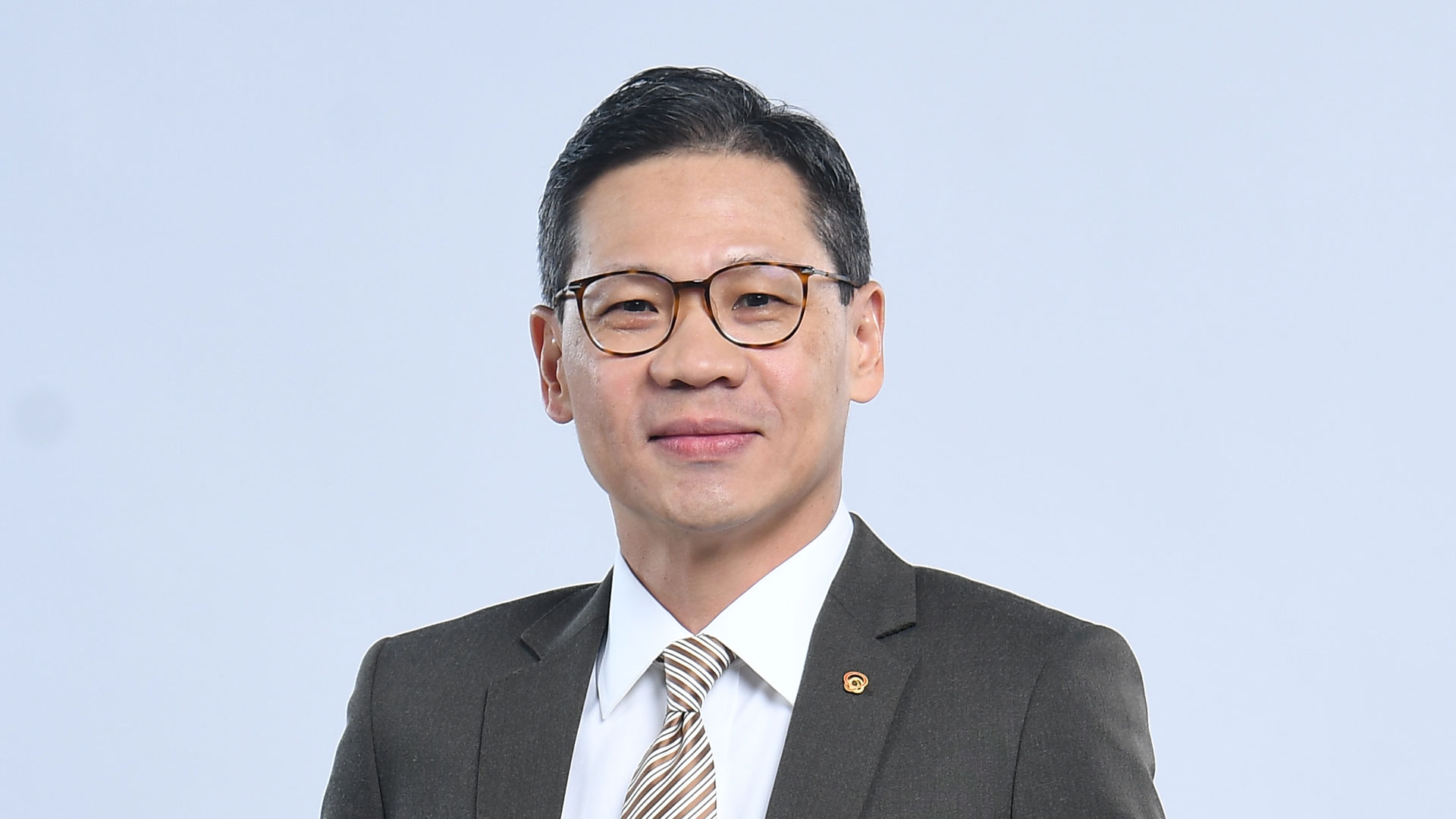 Indonesian businessman wearing glasses light blue background