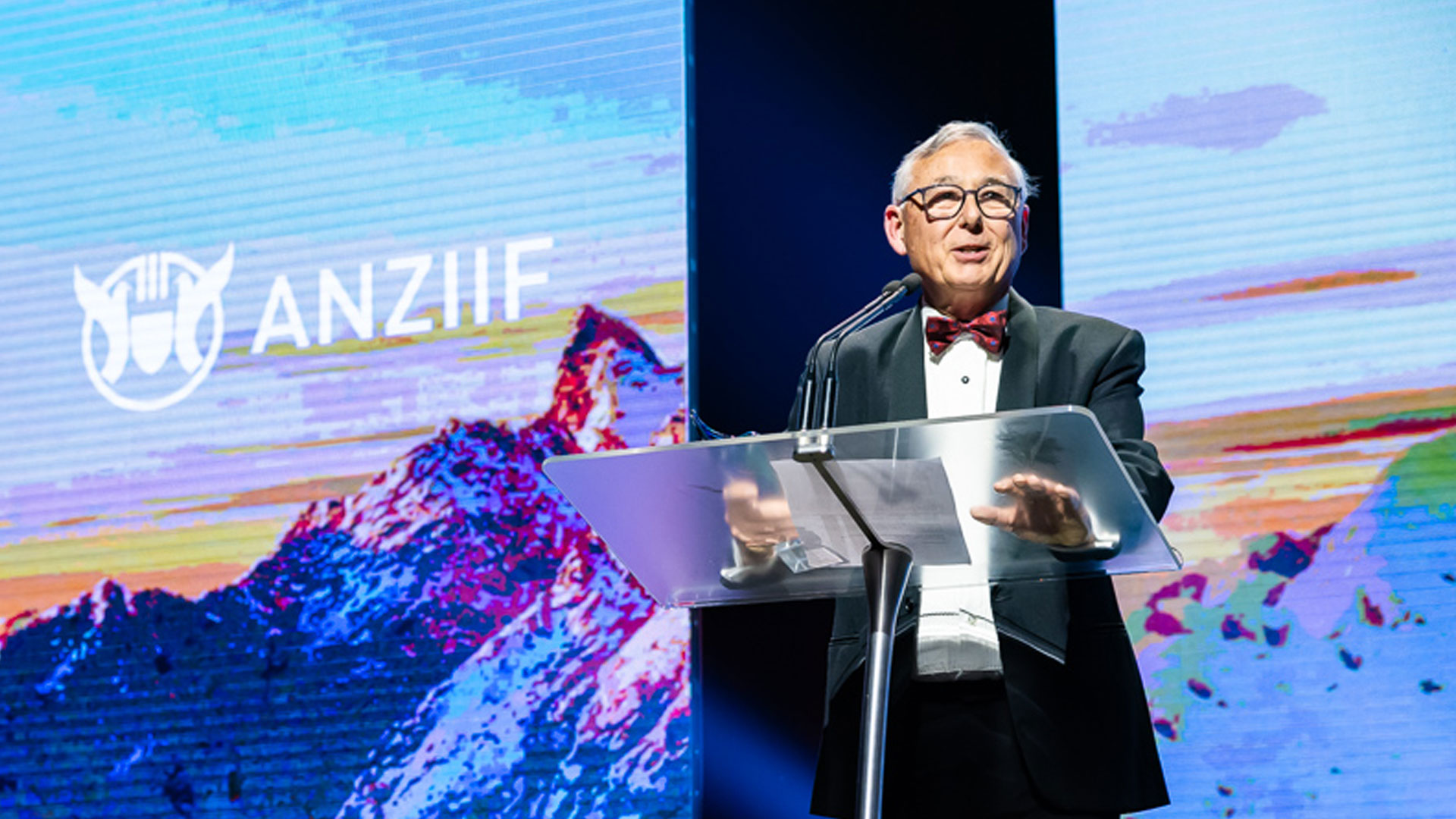 man with red bowtie makes a speech at podium