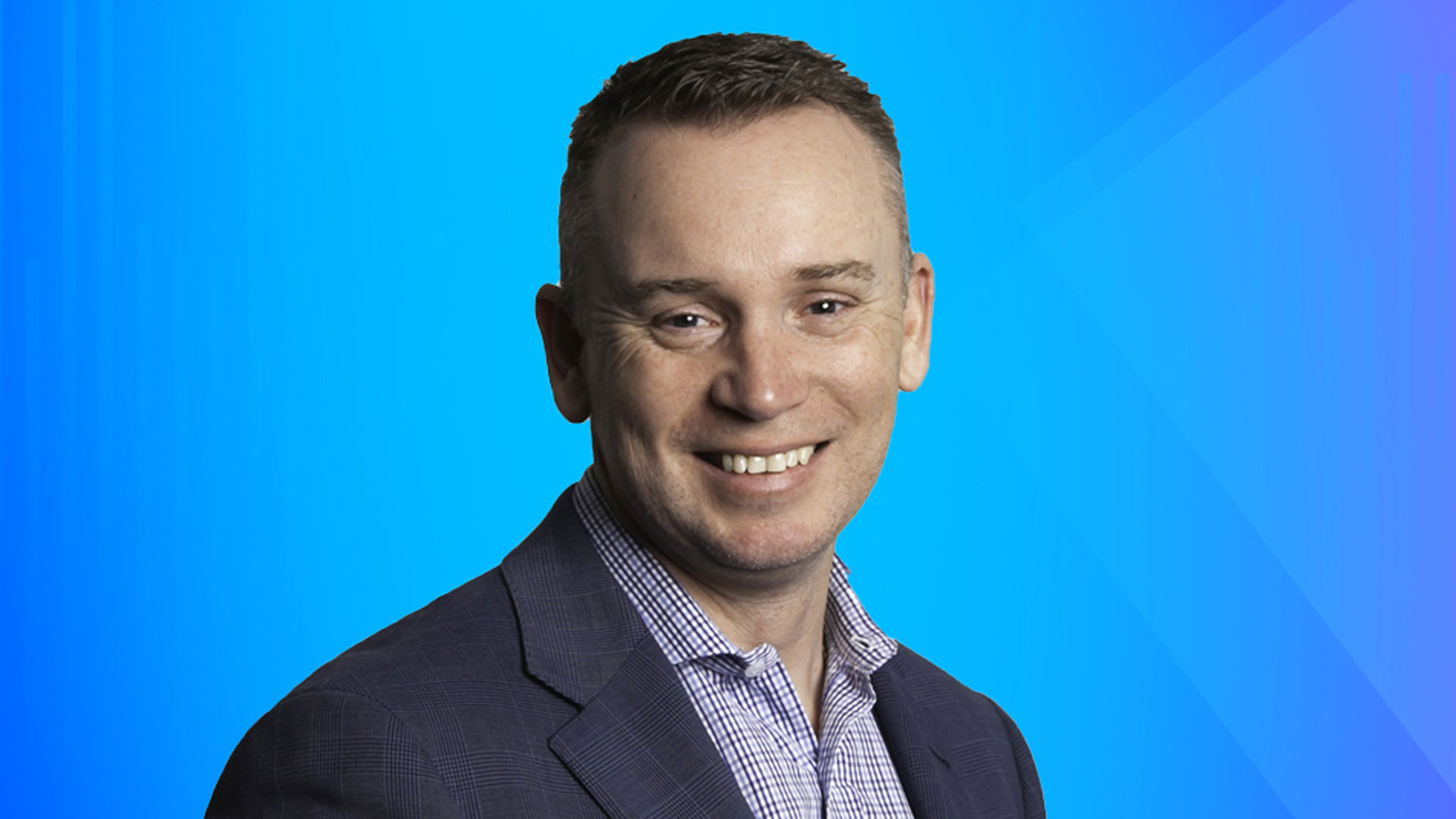 young man smiling in a suit no tie